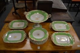 A dessert service with green and gilt decorated borders.