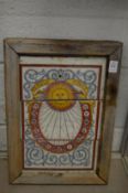 A tile plaque depicting a sundial, framed.