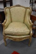 A French style painted armchair with floral upholstery.