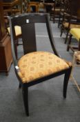 An Empire revival ebonised occasional chair.
