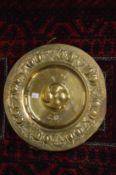 An Arts and Crafts embossed brass charger.