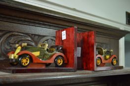 A pair of novelty wooden bookends modelled as cars.