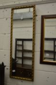 A gilt framed narrow mirror.