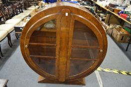 An Art Deco mahogany stained circular two door display cabinet.