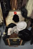 A large trunk containing numerous hats.