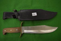 A large bowie type knife with scabbard.