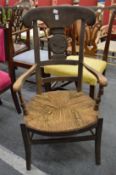 An unusual Continental rush seated armchair with pictorial carved roundel to the back.
