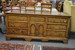 A good 18th century Lancashire oak dresser with an arrangement of seven drawers and a pair of