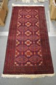 A Persian rug, dark red ground with stylised decoration 155cm x 80cm.