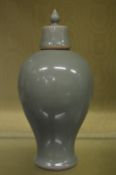 A Chinese celadon glazed baluster shaped vase and cover.