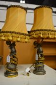 A pair of decorative cherub lamps.