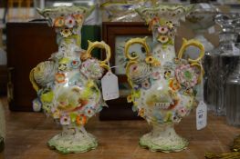 A pair of Continental floral encrusted porcelain twin handled vases.
