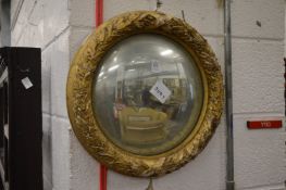 A convex mirror with gilded laurel wreath style frame.