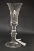 A Georgian glass with long tapering plain bowl, knop to the stem.