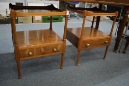 A pair of yew wood two-tier single drawer lamp tables.