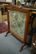 An oak framed fire screen with needlework panel.