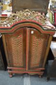 An Eastern carved hardwood painted and gilded low two door cupboard.