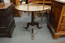 A 19th century oak tilt-top circular tripod table.