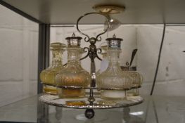 A plated revolving cruet with cut glass bottles.