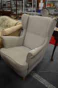 A modern grey linen upholstered armchair.