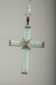 A silver opal and cubic zirconia cross on a chain in a box.