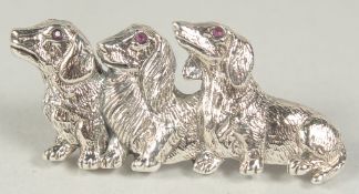 A silver dachshund brooch in a box.