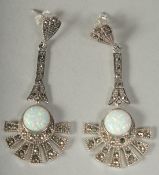 A silver and opal pair of drop Deco style earrings in a box.
