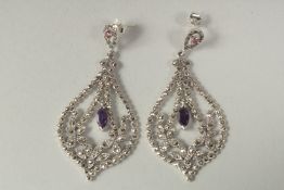 A pair of silver amethyst drop earrings in a box.
