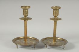 A FINE PAIR OF ISLAMIC SILVER INLAID BRASS CANDLESTICKS, 19cm high.