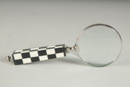 A MAGNIFYING GLASS with chequered handle.