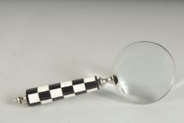 A MAGNIFYING GLASS with chequered handle.