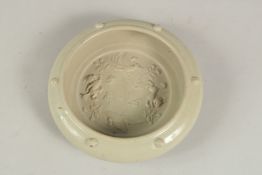 A Chinese celadon glazed moulded circular brush washer.