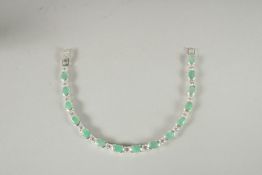 A SILVER EMERALD SET LINE BRACELET.