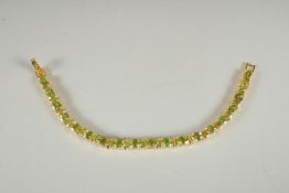 A SILVER , 18CT GOLD PLATED, PERIDOT SET LINE BRACELET.