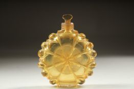 A CUT GLASS AMBER CIRCULAR SCENT BOTTLE AND STOPPER. 5.5cm diameter