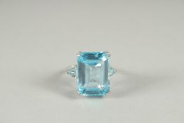 A LARGE SILVER EMERALD CUT TOPAZ RING.
