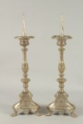 A GOOD PAIR OF PRICKET ALTAR CANDLESTICKS on triangular bases, with claw feet. 19.5ins high.