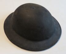A WWII British Brodie helmet with liner and chin strap, bears number 223 written inside.