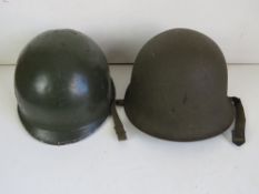 A US M1 helmet and a 1953 French helmet.