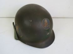 A US Vietnam M1 helmet with liner, dated 69, having been repainted.