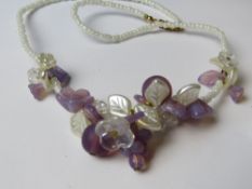 A contemporary beaded necklace and earring having floral and grape design in Oliver Weber