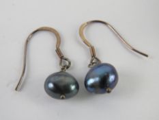 A pair of silver and black coloured pearl earrings. In presentation box.