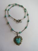 A Native American Navajo style sterling silver and turquoise necklace with heart shaped pendant on