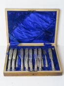 An oak canteen opening to reveal part fish knife and fork set having HM silver handles.