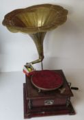 A vintage gramophone with a wind mechanism and handle, having brass horn,