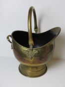 A brass helmet style coal scuttle with swing handle over.