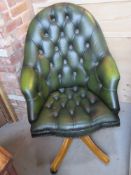 A green leatherette Chesterfield style office chair having high back and pine base,
