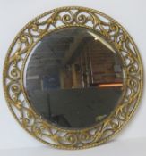 A 1950s circular wall mirror by Atsonfa, having carved and gilded frame, bevelled edge glass,