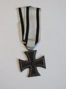 A reproduction WWI German Iron Cross with ribbon.