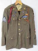A WWII US Airborne tunic, having all buttons and numerous patches and badges.